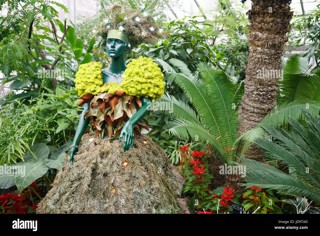 Mannequin mit Kleid hergestellt aus Pflanzen im Ziergarten mit unterschiedlichsten Pflanzen und Blumen Stockfoto