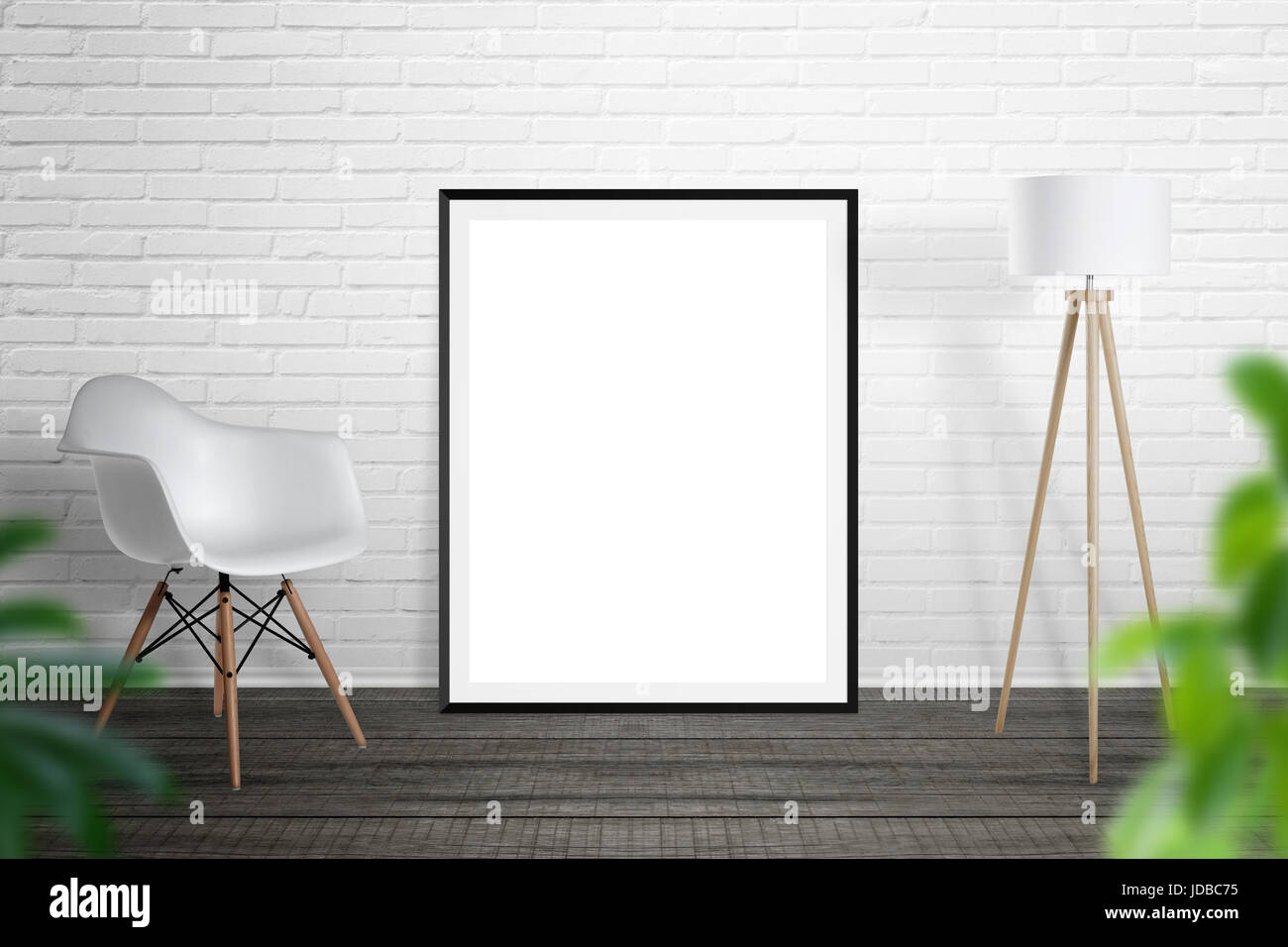 Leerer Grafikrahmen stützte sich auf Mauer. Stuhl und Lampe neben. Stockfoto