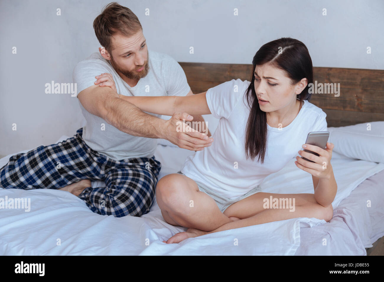 Frustriert jungen Mann unter seine Freundin smartphone Stockfoto