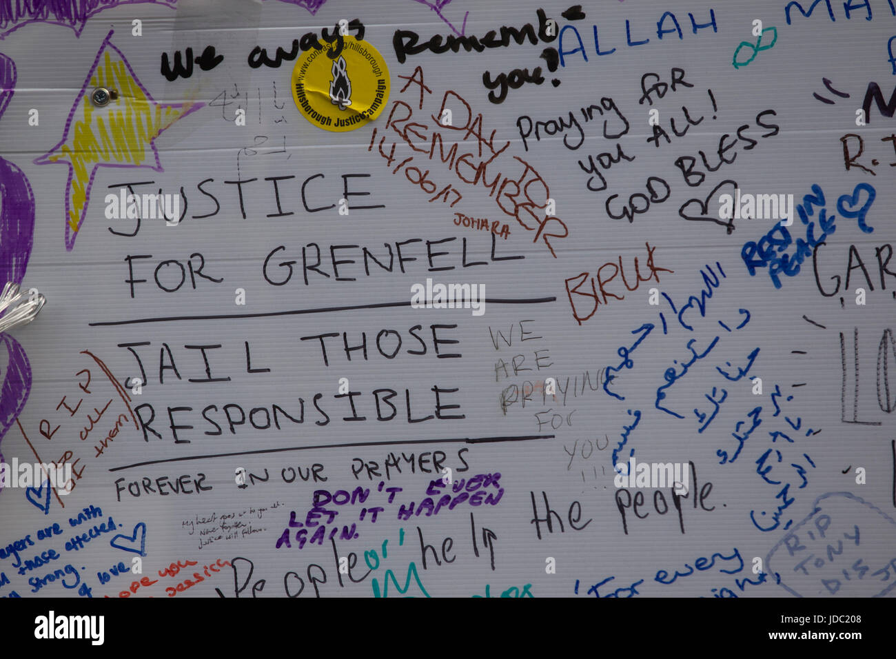 Menschen verlassen Hommagen an einer Wand aus Anteilnahme für die Opfer starb Grenfell Turm, das 27-geschossige Hochhaus Feuer in West London, England, UK Stockfoto