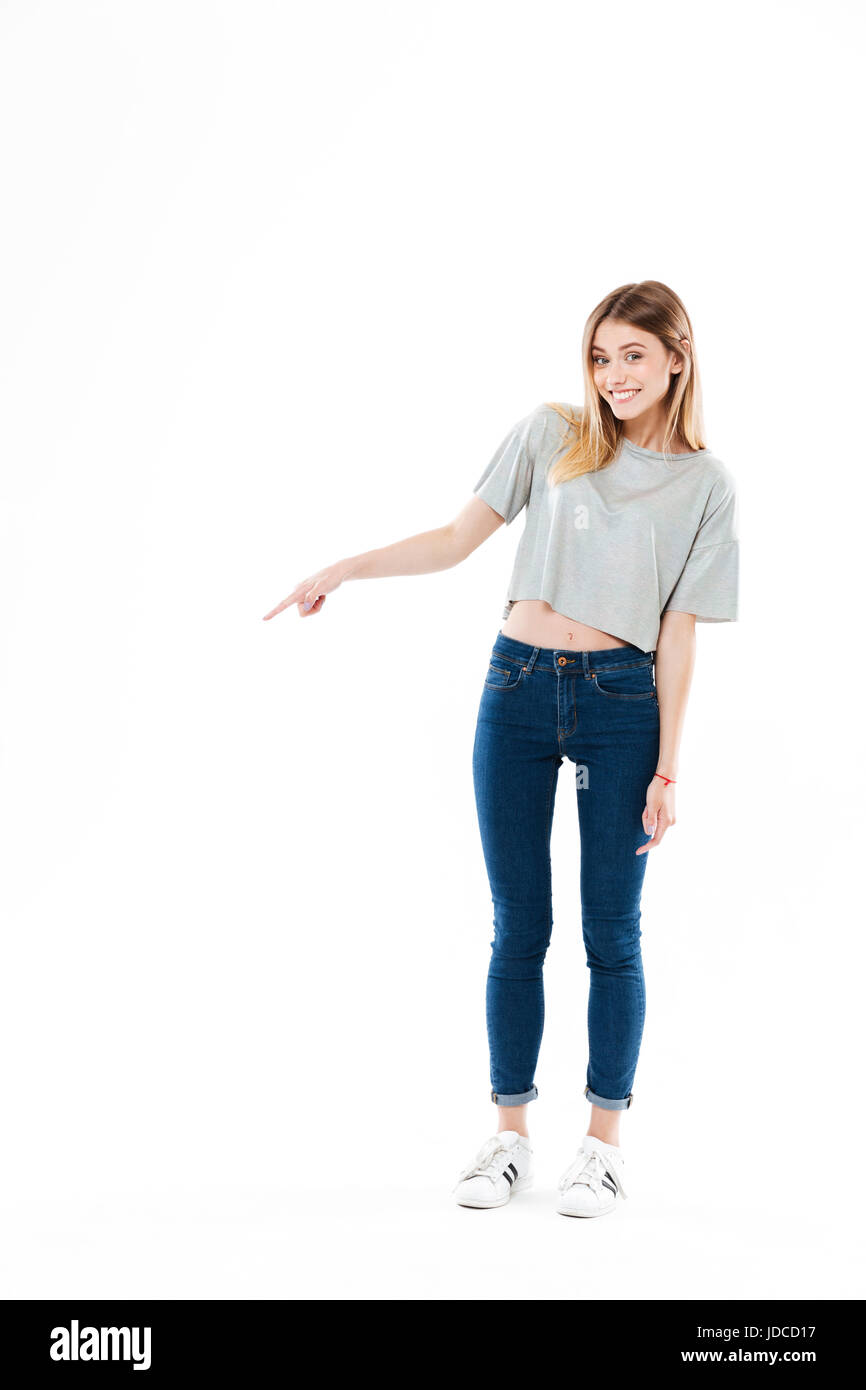 Voller Länge von einem glücklich lächelnde Mädchen stehen und Fingerzeig entfernt auf textfreiraum isoliert auf weißem Hintergrund Stockfoto