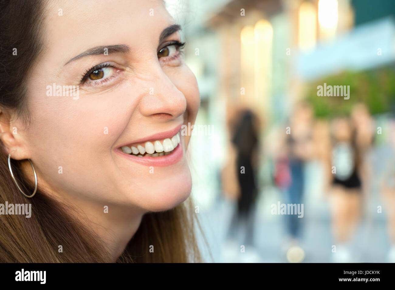 Porträt einer Frau lächelnd, fröhlich, an der Kamera, closeup suchen, im freien Hintergrund. Stockfoto
