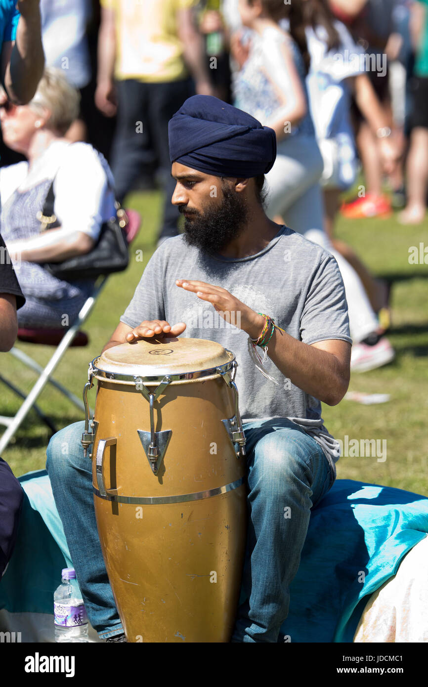 Junger Mann mit Turban, afrikanischen Trommeln auf dem Africa Oye-Musik-Festival in Sefton Park Liverpool spielen lernen Stockfoto