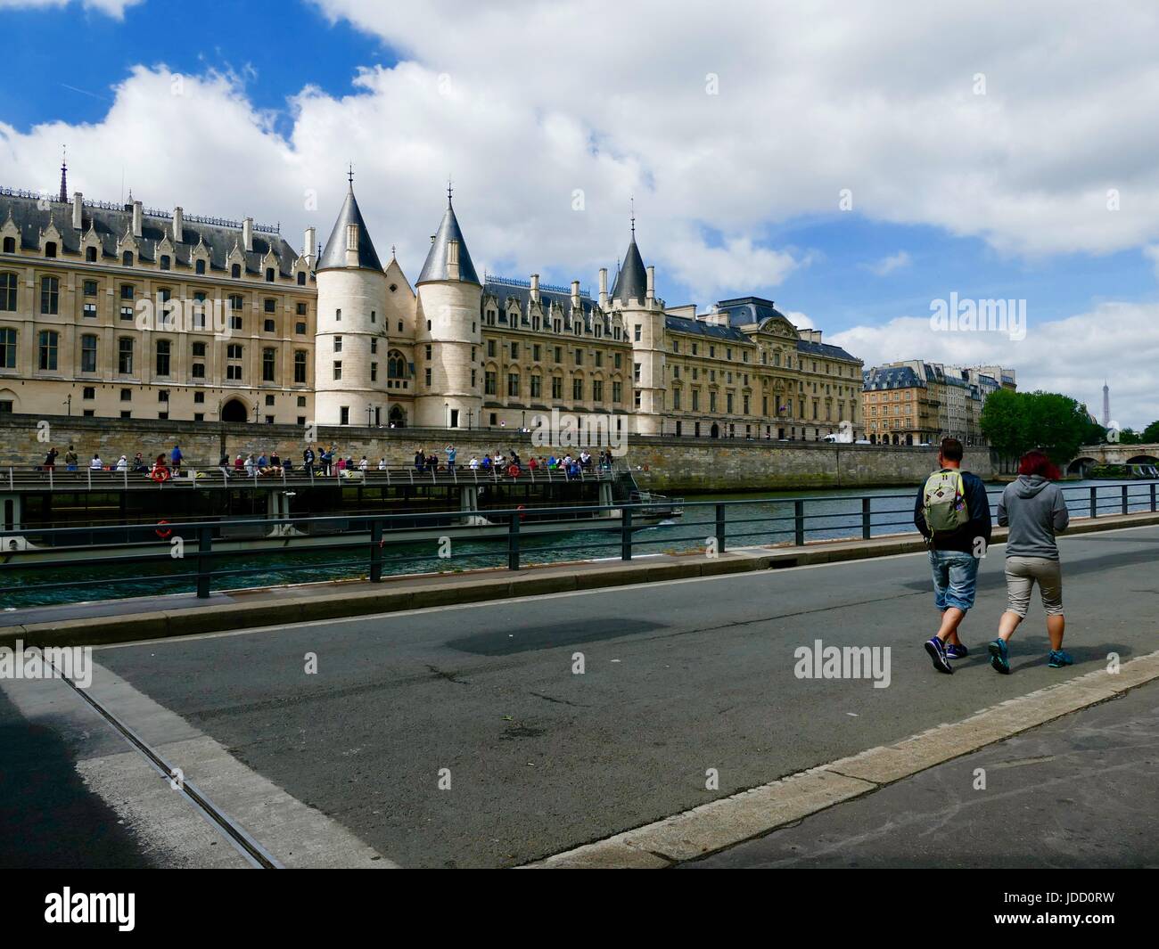 Zwei Männer zu Fuß entlang Parc Rives de Seine, an einem touristenboot vorbei schauen. Paris, Frankreich Stockfoto