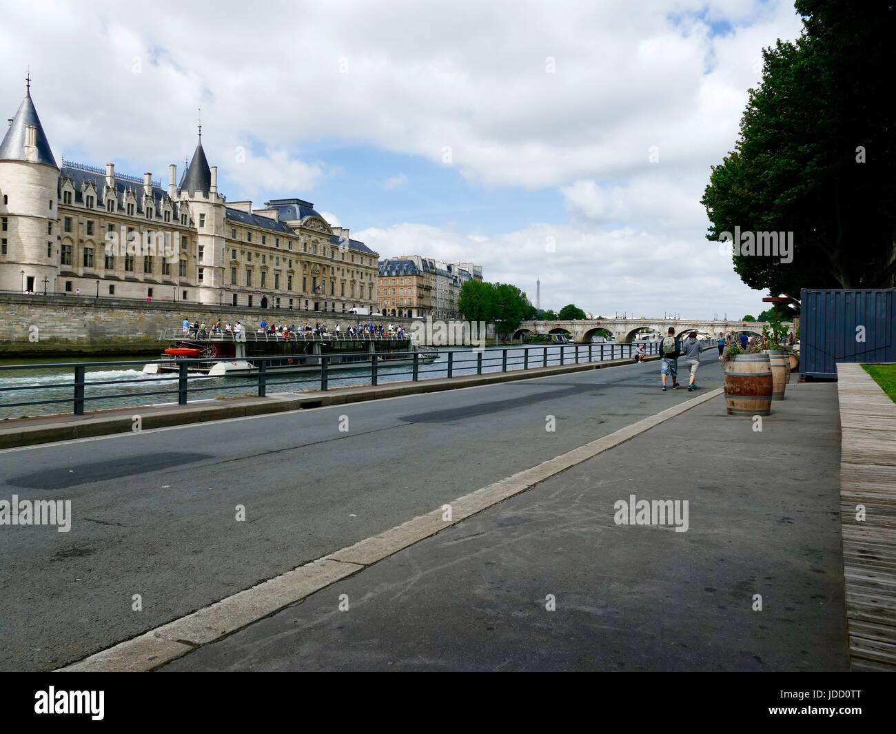 Zwei Männer zu Fuß entlang Parc Rives de Seine, an einem touristenboot vorbei schauen. Paris, Frankreich Stockfoto