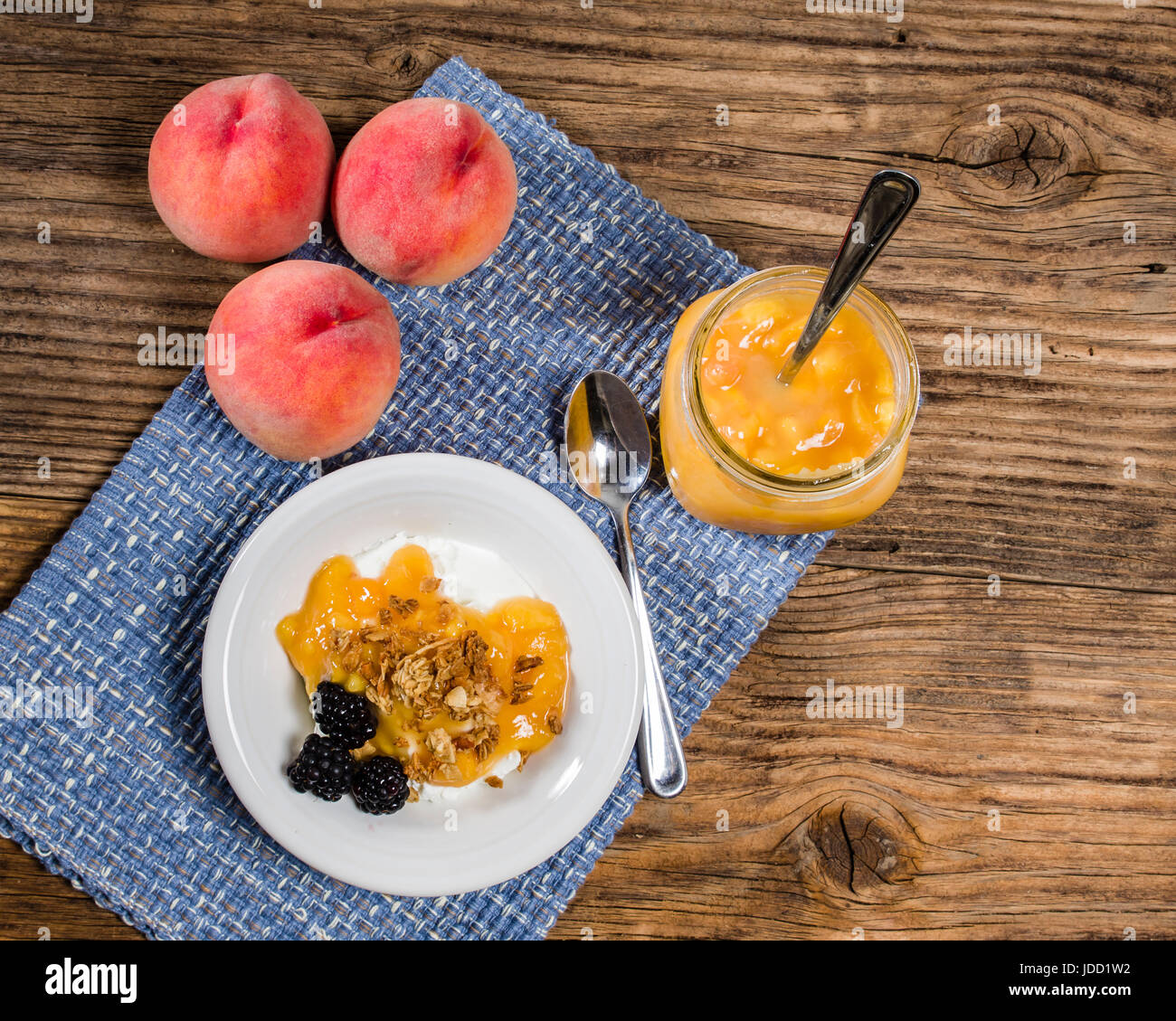 Reife saftige gelbe Pfirsiche und Joghurt auf rustikalen Tisch Stockfoto