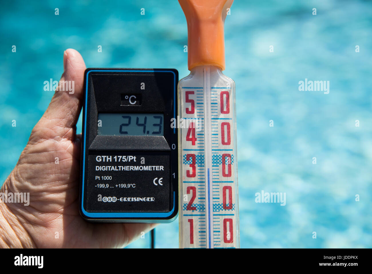 Ein Bademeister misst die Temperatur des Wassers, derzeit bei 24,3 Grad Celsius, in einem öffentlichen Freibad in Nürnberg, 20. Juni 2017. Ein anderes Thermostat zeigt die Luft-Temperatur von 34 Grad Celsius. Foto: Daniel Karmann/dpa Stockfoto