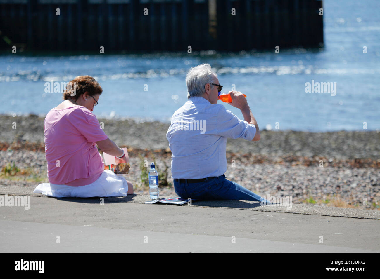 Largs, UK. 20. Juni 2017. Warmen, sonnigen Tag in Largs an der Clyde-Küste. Ein Mann genießt einen kühlen Drink von Irn Bru. Bildnachweis: ALAN OLIVER/Alamy Live-Nachrichten Stockfoto