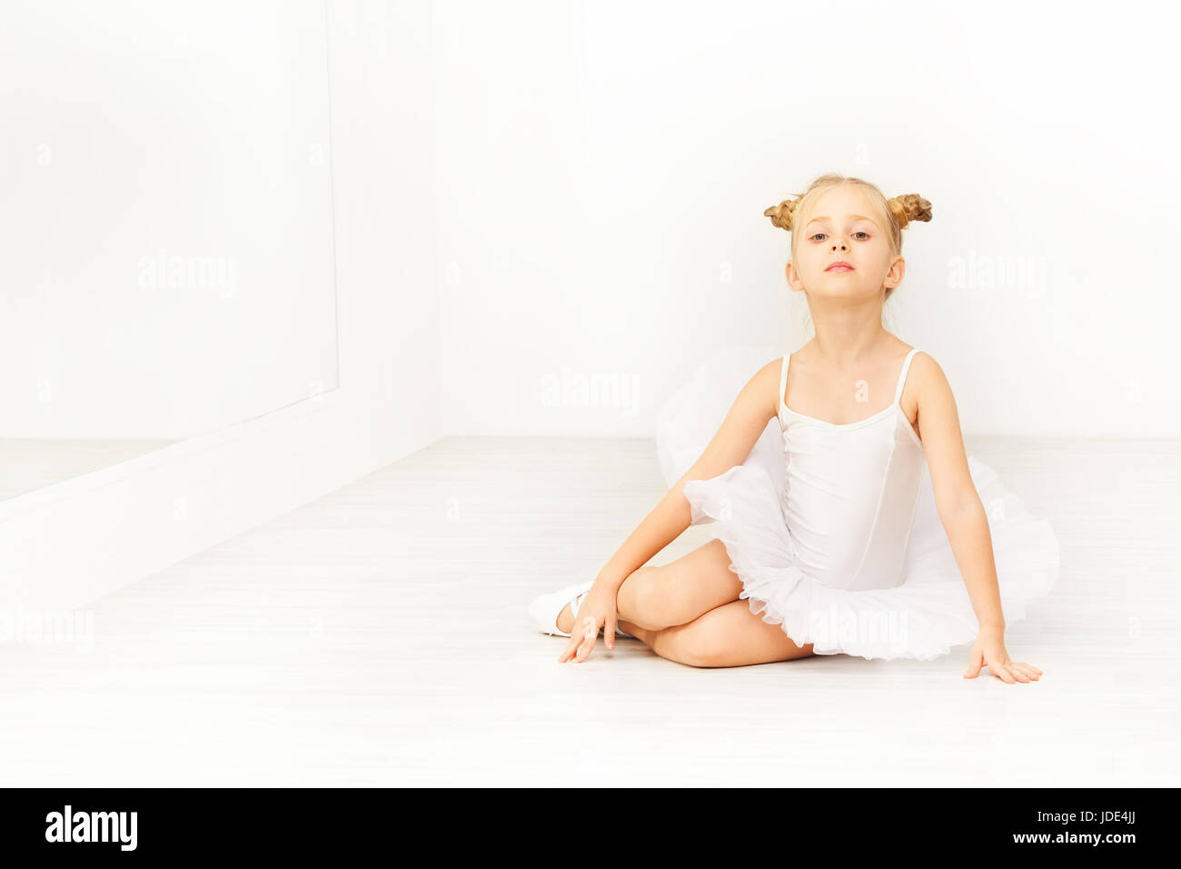 Porträt der Tänzerin, schöne sechs Jahre altes Mädchen in weißen Tutu, sitzen auf dem Boden des leichten Ballettstudio Stockfoto