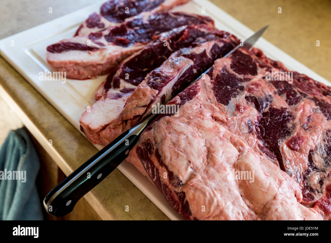 Hause Schlachten ein Rind Lende in New York Steaks geschnitten Stockfoto