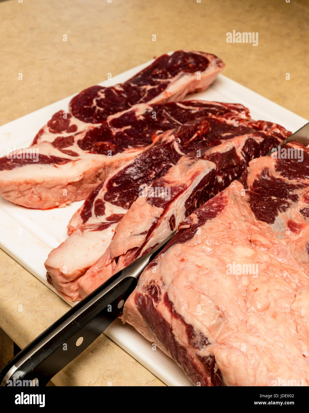 Hause Schlachten ein Rind Lende in New York Steaks geschnitten Stockfoto