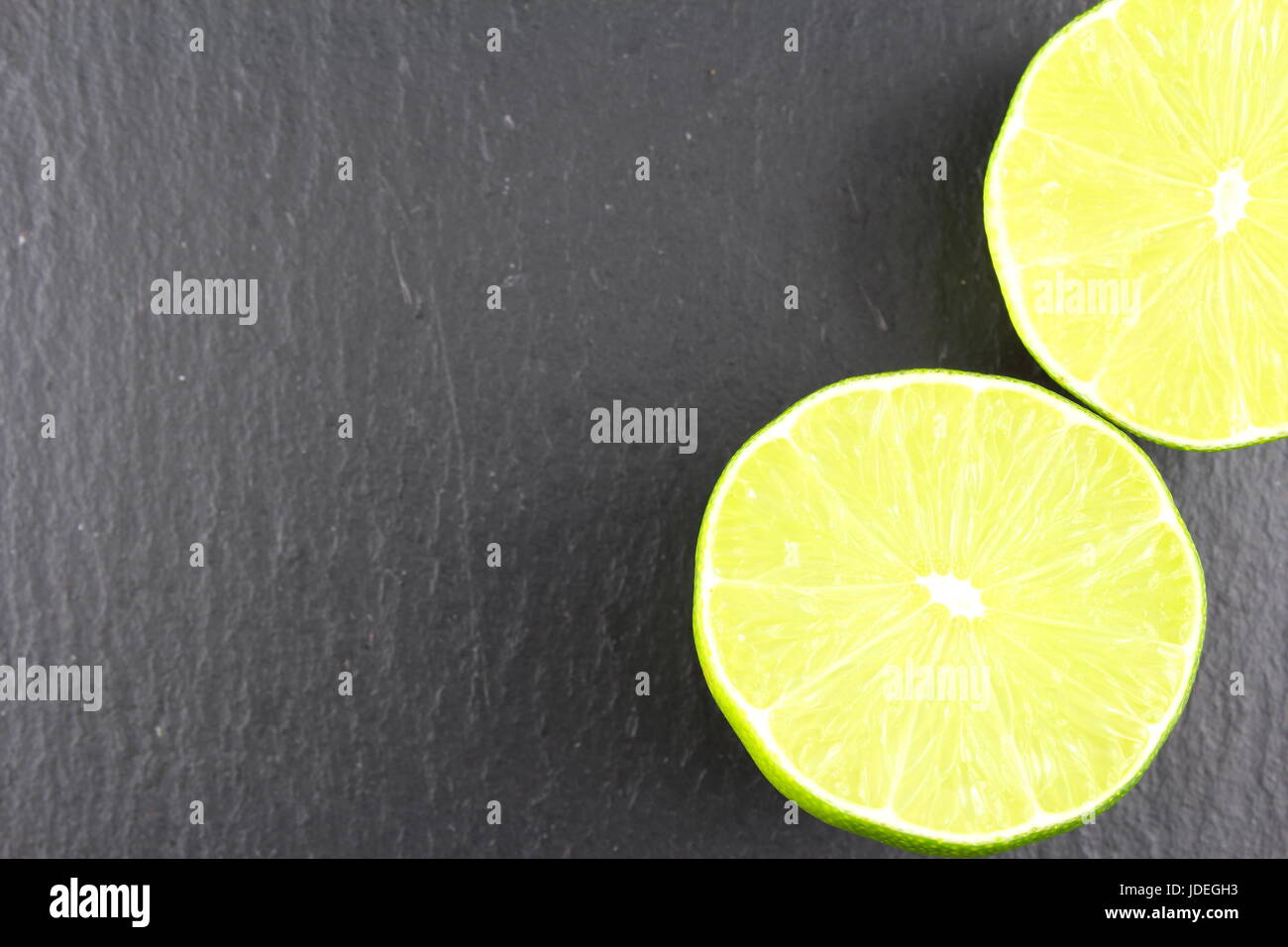 frische Limette Obst auf einem Schiefer Teller als eine Hintergrundtextur Essen Stockfoto