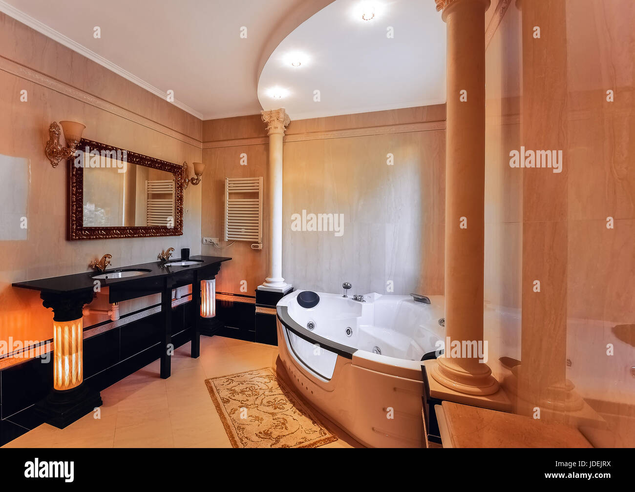 Luxuriöses Badezimmer im klassischen Stil mit korinthischen Säulen. Badezimmer mit zwei Waschbecken und einem Whirlpool.  Die Böden und Wände mit Marmor. Stockfoto