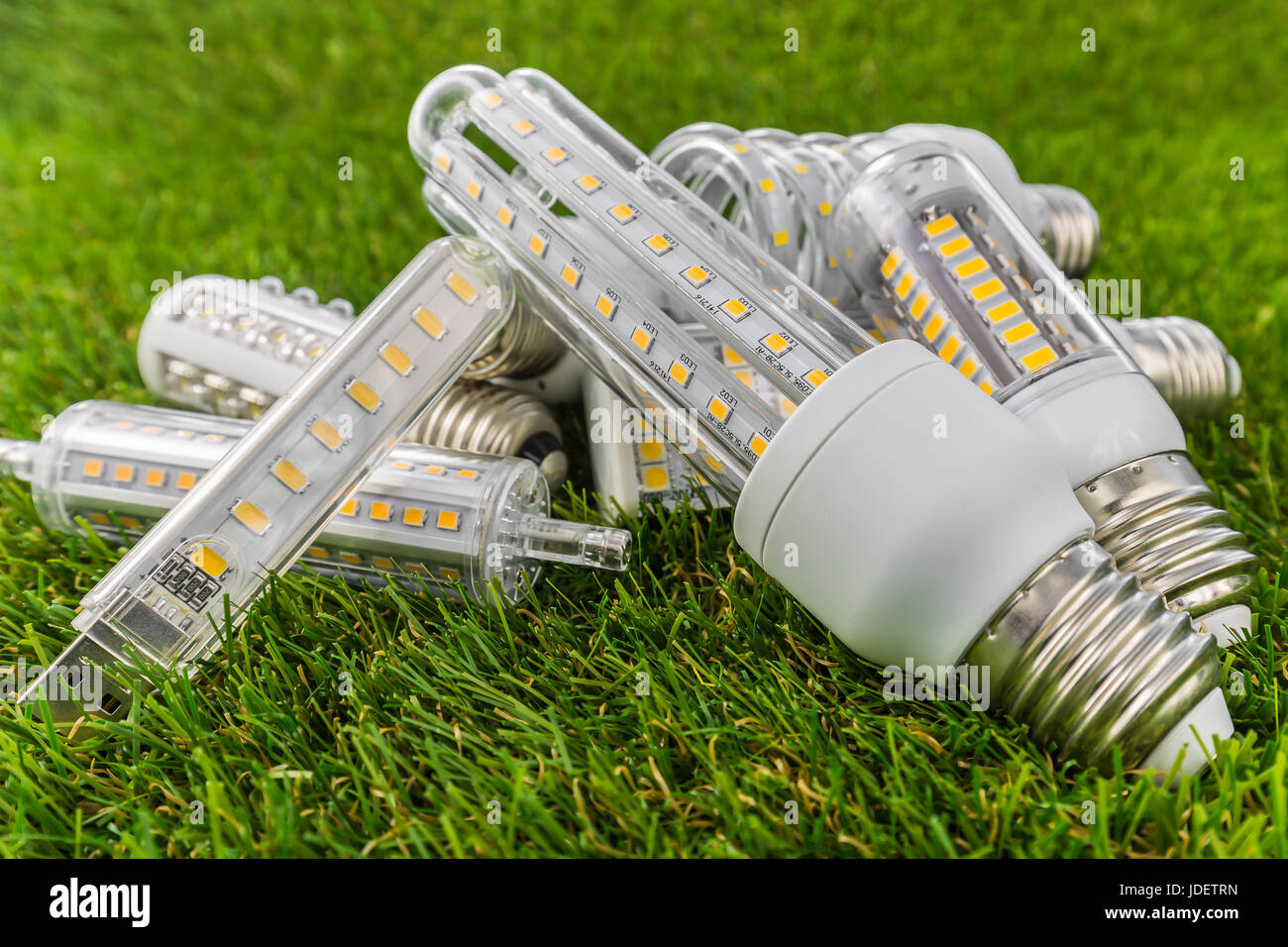 verschiedene Arten von ökologischer und wirtschaftlicher LED-Lampen (E27 ähnliche Form als CFL) auf der grünen Wiese Stockfoto