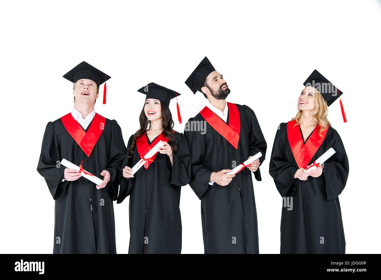 Gruppe von jungen Männern und Frauen in der Graduierung Kleider und Mortarboards hält Diplome Stockfoto