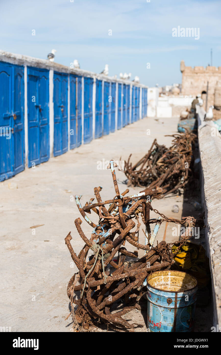 Rostiger Anker liegen an der Seite eines Pfades mit blauen Schließfächer für die Fischer in Essaouira, Marokko Stockfoto