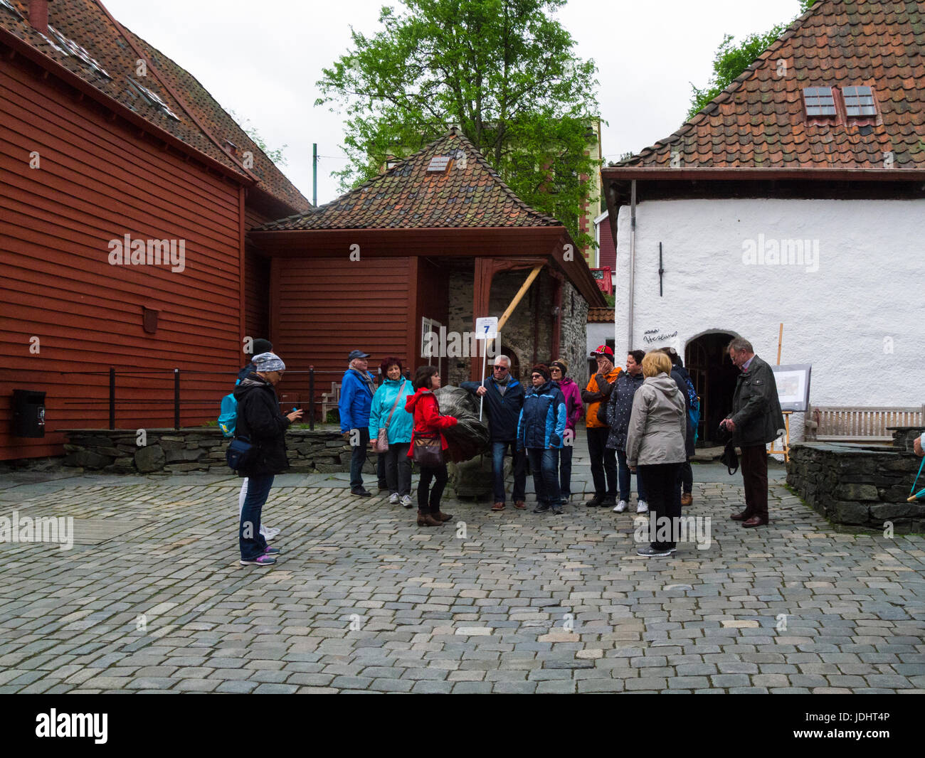 Touristen auf einen Rundgang durch deutsche Wharf Bryggen Bergen Norwegen zum UNESCO-Weltkulturerbe Stockfoto