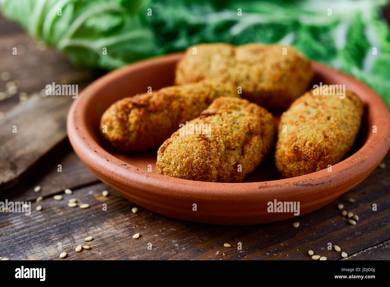 Nahaufnahme eines Steingut Platte mit einige hausgemachte Croquetas, spanische Kroketten auf einem rustikalen Holztisch Stockfoto