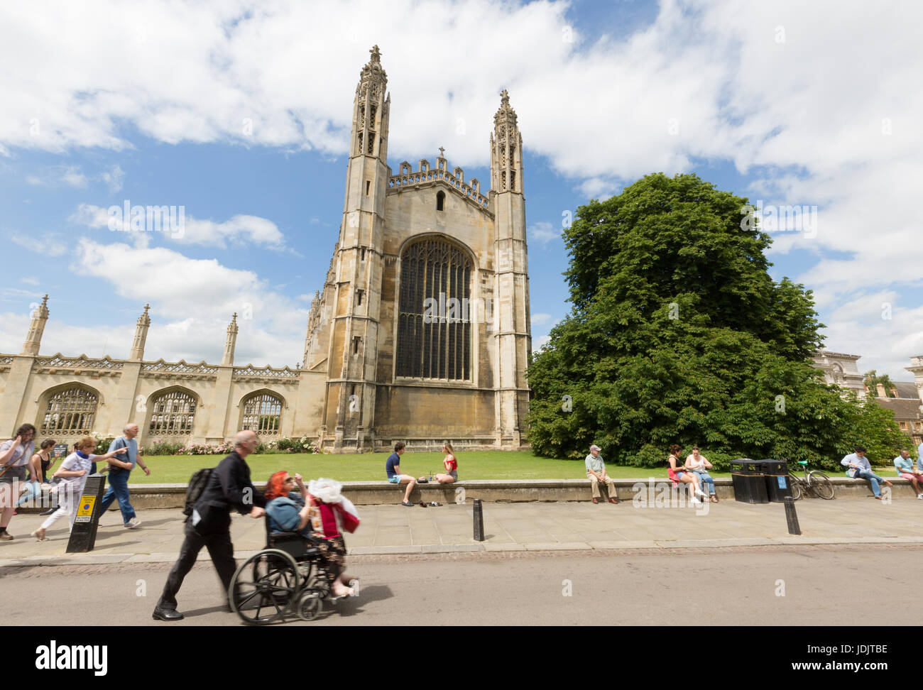 Ein Mann drückt eine behinderte Frau in einem Rollstuhl vorbei Kings College Chapel, Kings Parade, Cambridge UK Stockfoto