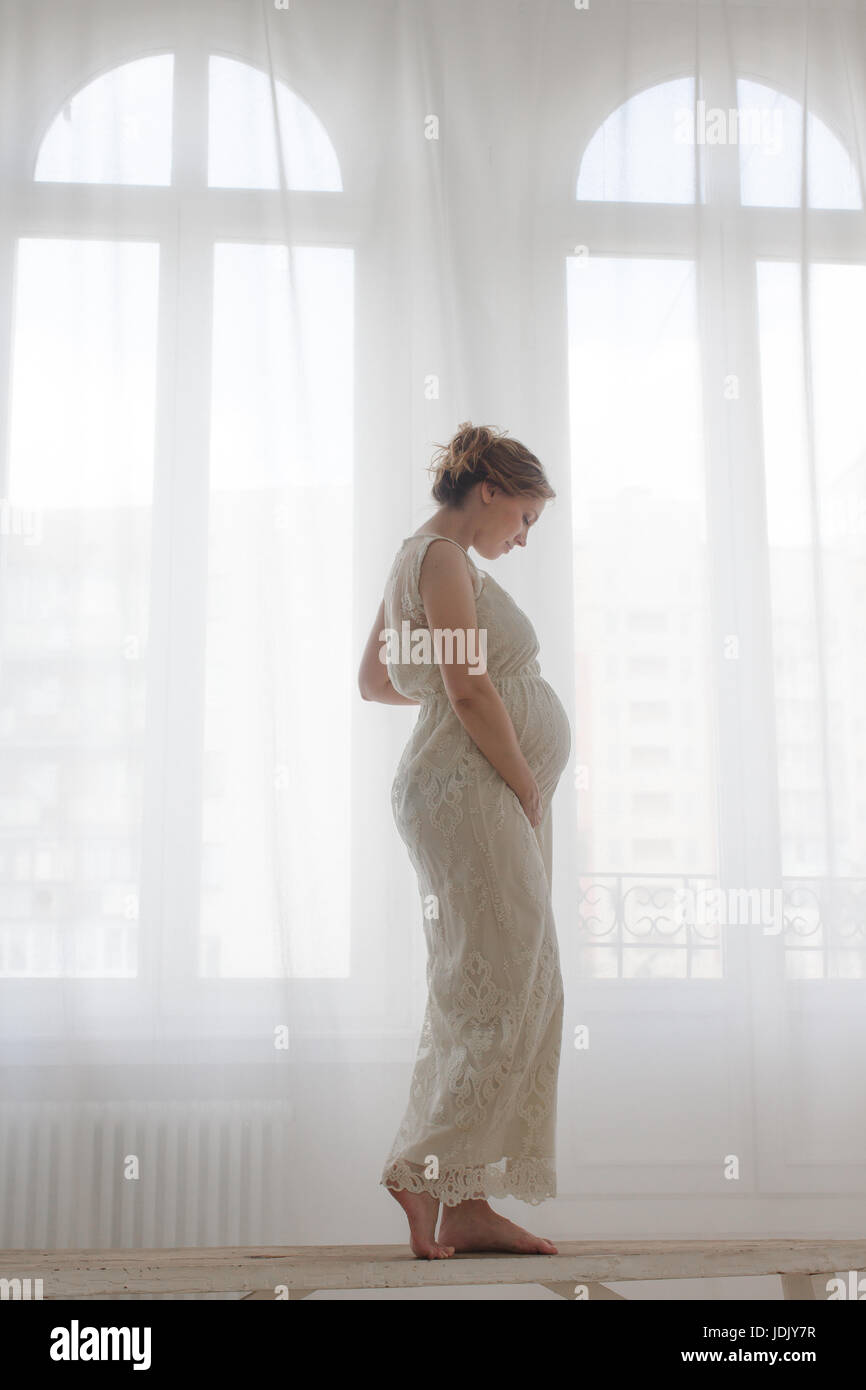Elegante schwangere Frau auf der Werkbank Stockfoto