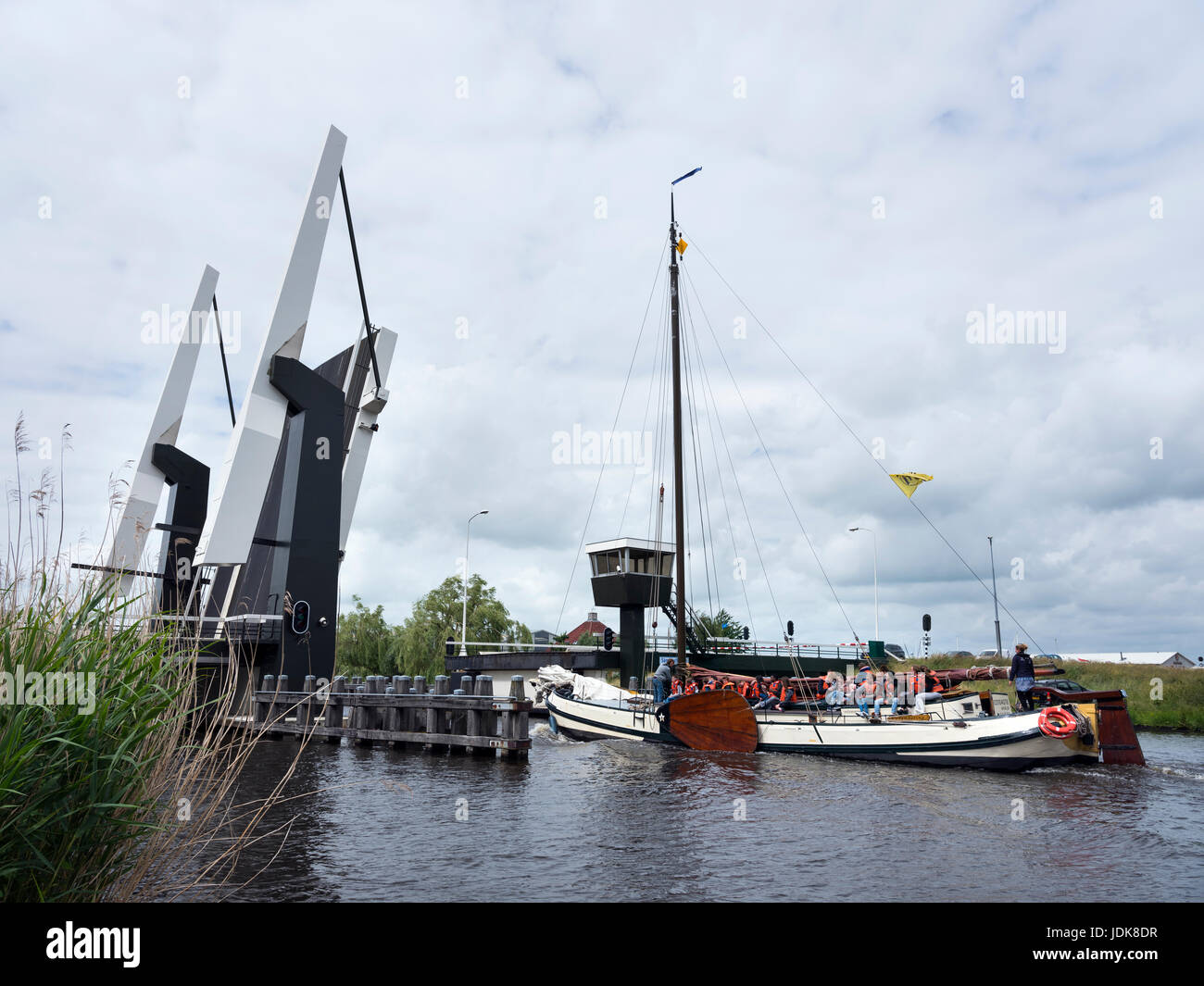 alten typischen hölzernen Segelschiff mit vielen Kindern auf Segelurlaub am See in der Nähe von Sneek in niederländischen Provinz Friesland in der Nähe von offenen Zugbrücke Stockfoto