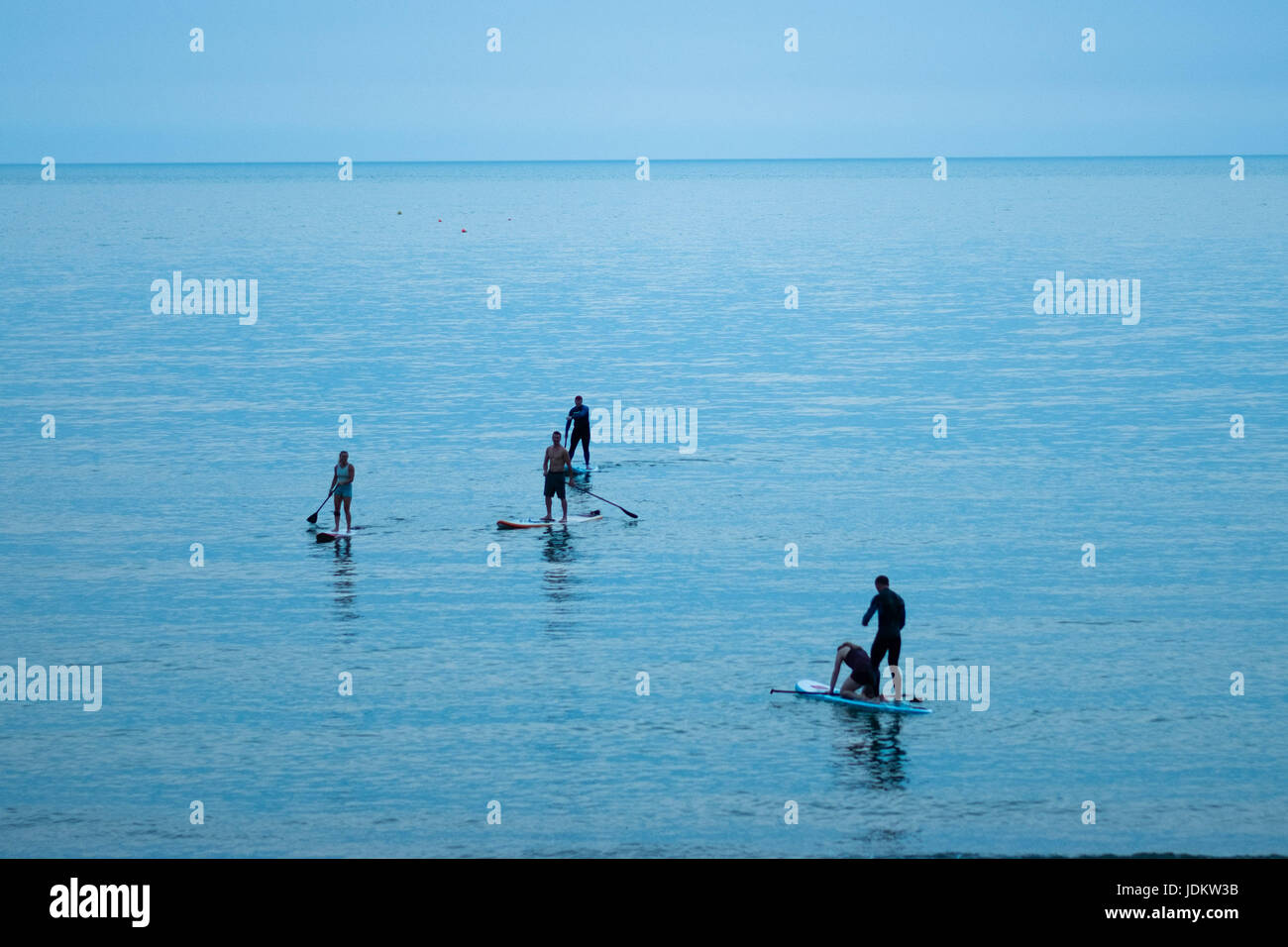 Aberystwyth Wales UK, Dienstag, 20. Juni 2017 UK Wetter: eine Gruppe Menschen auf Paddel boards in der Abenddämmerung auf dem flachen ruhige Meer in Aberystwyth nach einem weiteren schwülen Tag des klaren, blauen Himmel und sengende Hitze an der West Küste von Wales als Mini-Hitzewelle über den britischen Inseln weiter.    Das Met Office hat davor gewarnt, von starkem Regen und Gewitter mit der Chance auf lokalisiert Überschwemmungen betroffen viel des Vereinigten Königreichs in den nächsten 24 Stunden als Wetter-System beginnt zu brechen nach vielen Tagen der Rekord Höhe Temperaturen © Keith Morris / Alamy Live News Stockfoto