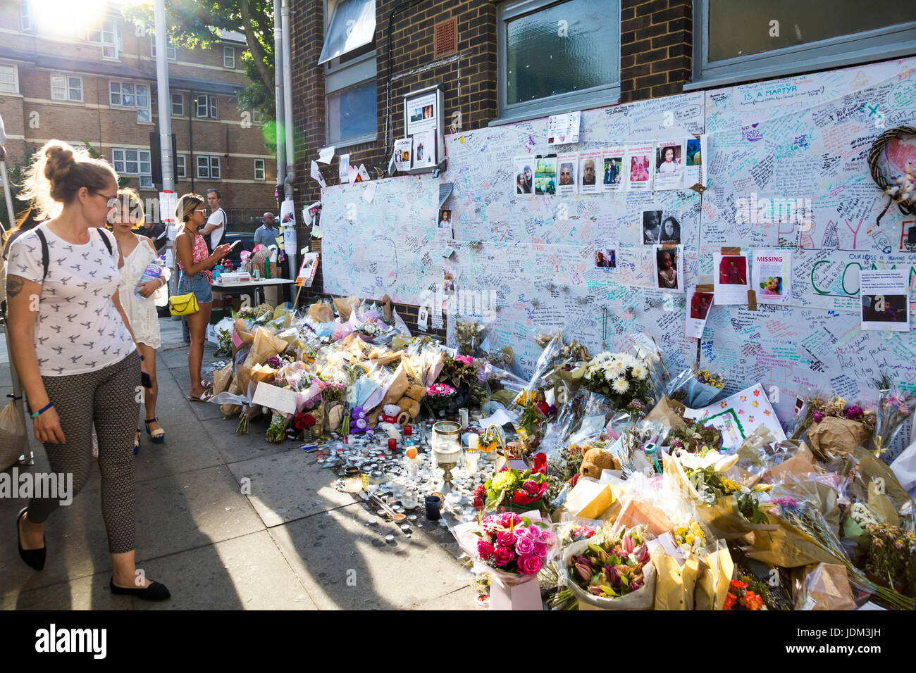 London, UK. 20. Juni 2017 - am 14. Juni 2017 Grenfell Tower, einem 24 Stockwerke hohen Turm Wohnblock Sozialwohnungen in North Kensington, West London, England wurde durch einen Brand schwer beschädigt verursacht eine hohe Anzahl von Opfern. Menschen sind gekommen, um Blumen zu legen und zahlen Tribut zu den Opfern, die bei dem Brand ums Leben gekommen. Stockfoto