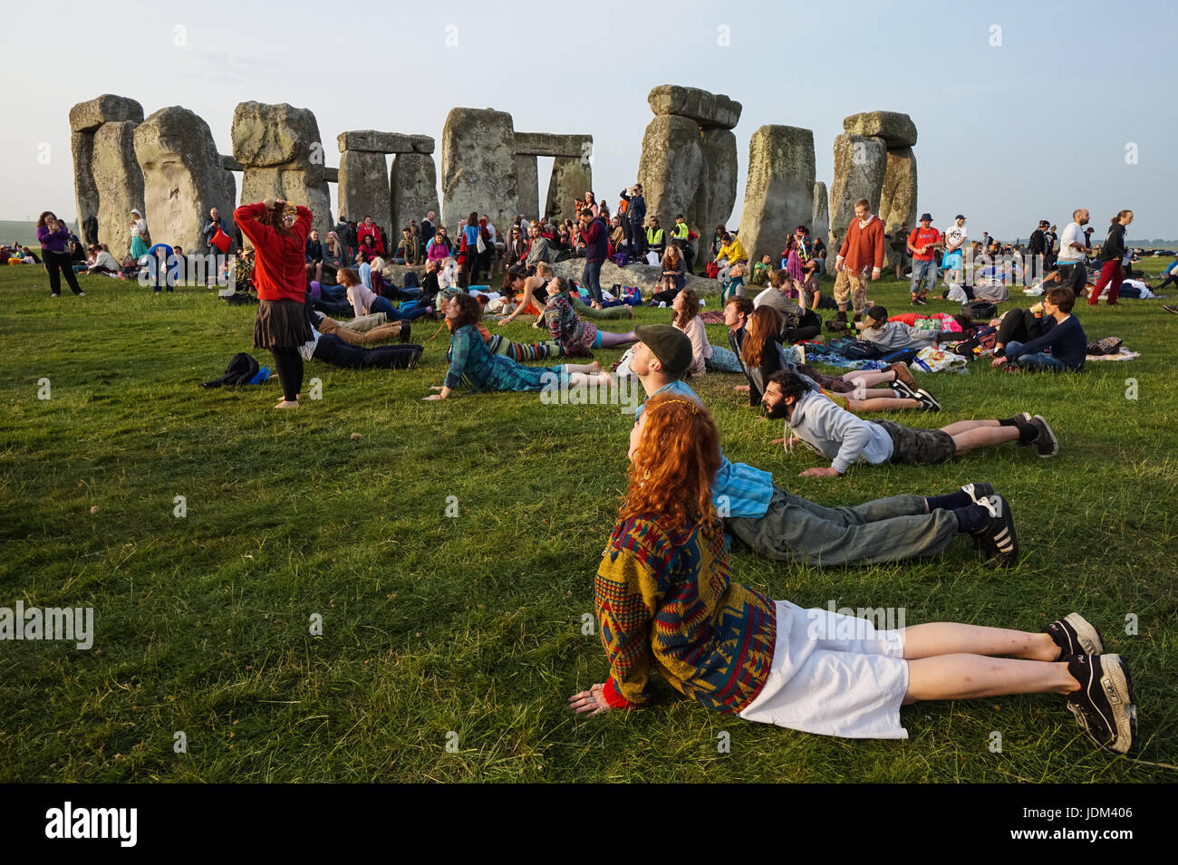 Sommersonnenwende feiern in Stonehenge. Menschen üben Yoga bei Sonnenaufgang, Stonehenge, Wiltshire, England, Vereinigtes Königreich, Großbritannien Stockfoto