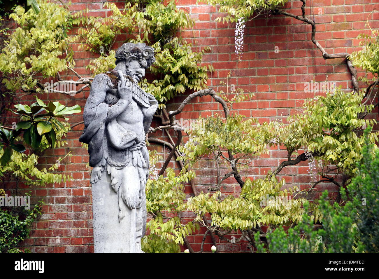 Statue des griechischen Gott Pan in einem ummauerten Garten Stockfoto