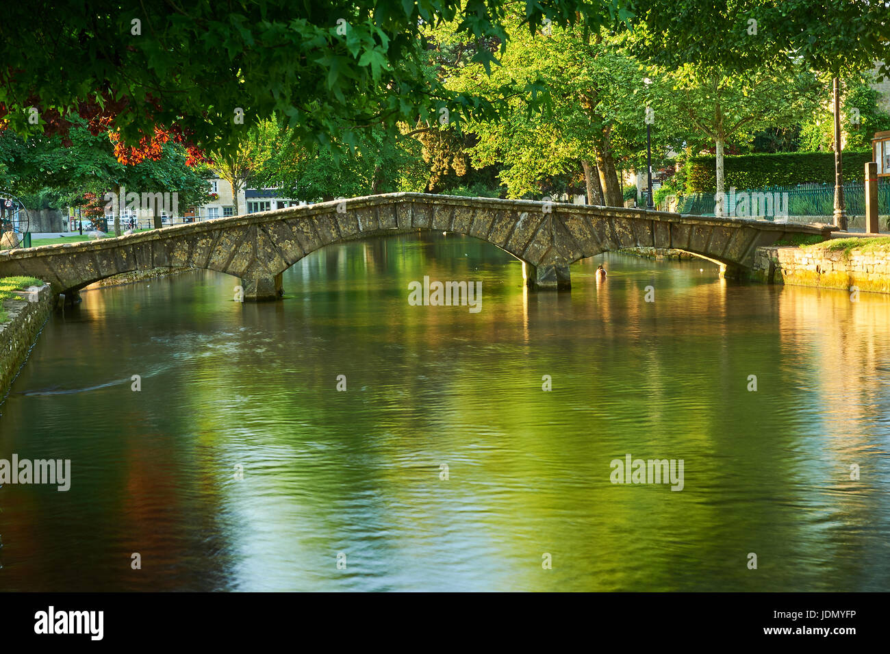 Ein Sommermorgen und kleinen steinernen Stege über den Fluss Windrush im malerischen Cotswolds Dorf von Bourton auf dem Wasser, Gloucestershire Stockfoto