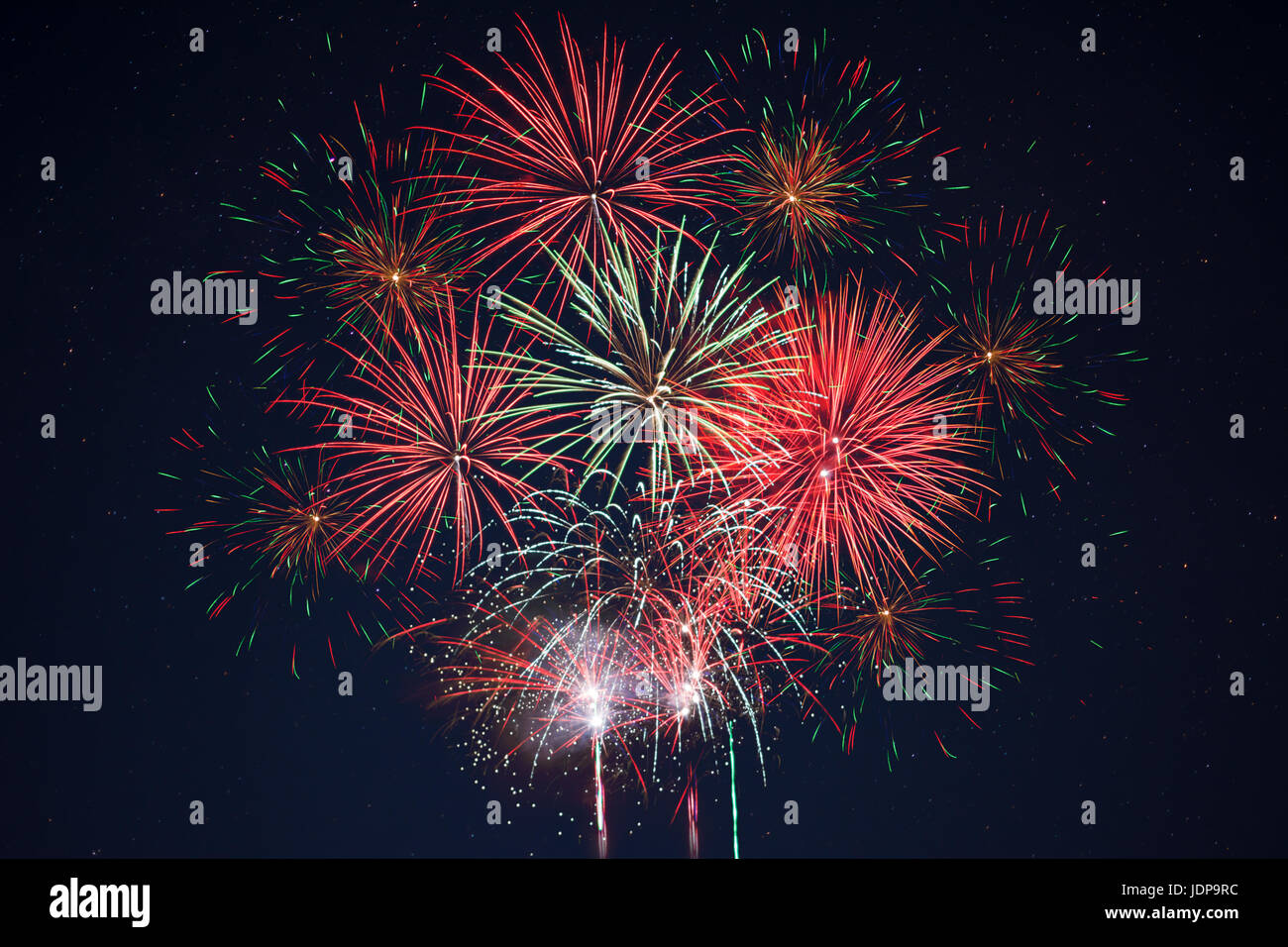 Funkelndes rot grün gelb Feier Feuerwerk über Sternenhimmel.  Independence Day, 4. Juli, Silvester Urlaub Gruß Hintergrund. Stockfoto