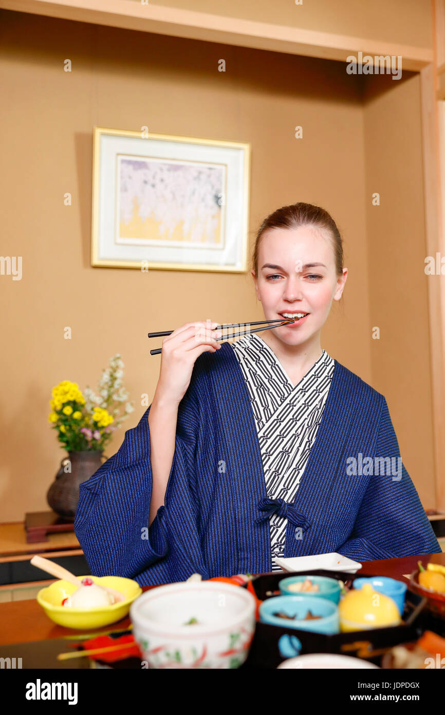 Kaukasische Trägerin Yukata Essen im traditionellen Ryokan, Tokyo, Japan Stockfoto