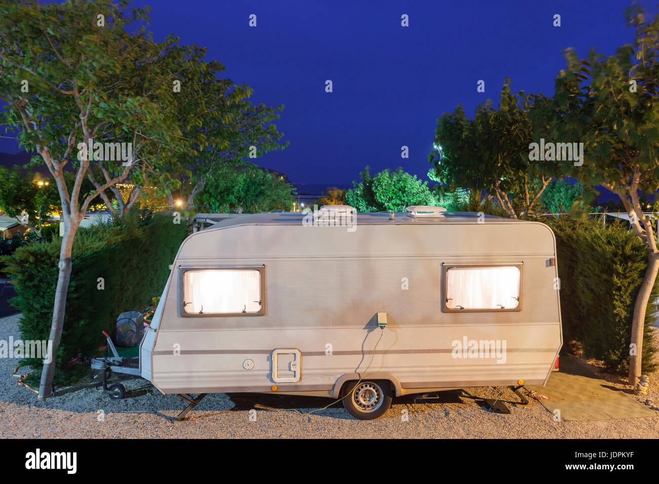 Wohnmobil oder Wohnwagen auf einem Campingplatz nachts beleuchtet Stockfoto