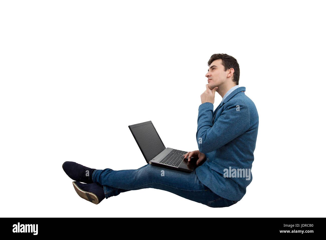 Ernsthafte Jungunternehmer mit einen nachdenklichen Blick auf Boden mit Laptop sitzen. Konzept, Idee und Zukunft. Stockfoto