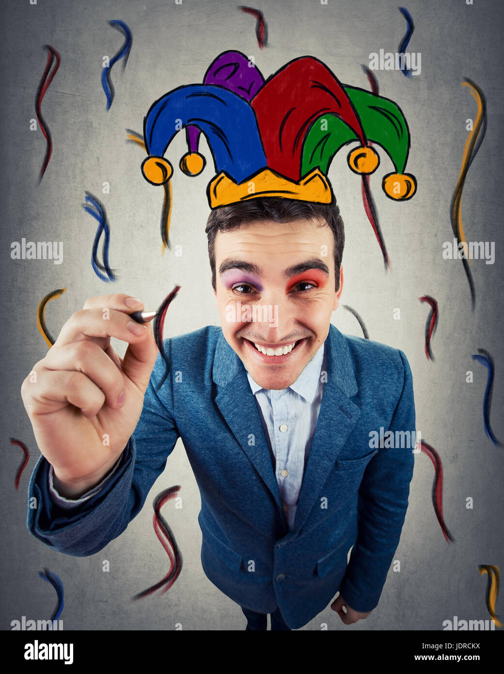 Nahaufnahme eines lächelnden Geschäftsmann als Clown ertrinken selbst ein Narr, Harlekin Hut. Menschlichen Ausdruck und Emotionen, Comic-Stil, Freizeit und Spaß. Stockfoto