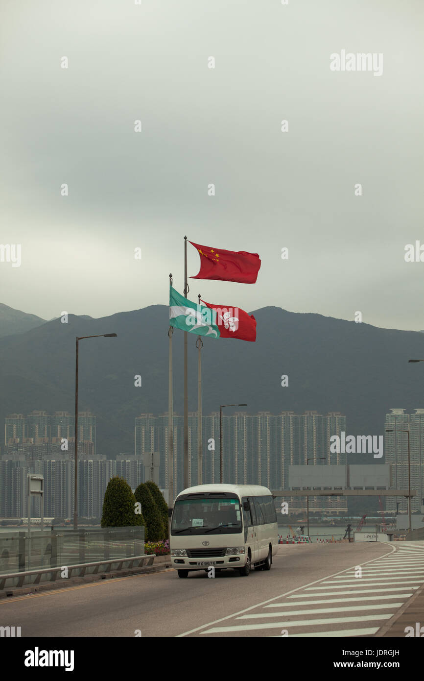 Chinesischer Zustand-Markierungsfahne mit Hong Kong SAR Flagge am Hong Kong international Airport; Shuttle-Bus, Ankunft am Abflug-Flughafen-terminals Stockfoto