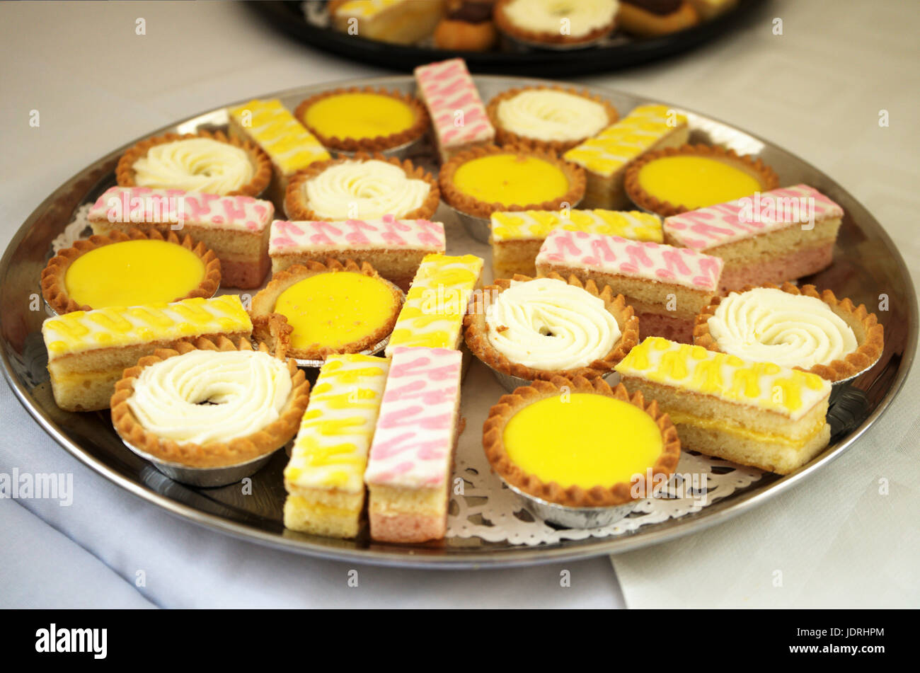 Auswahl an Kuchen und süße Leckereien auf einem Tablett präsentiert Stockfoto