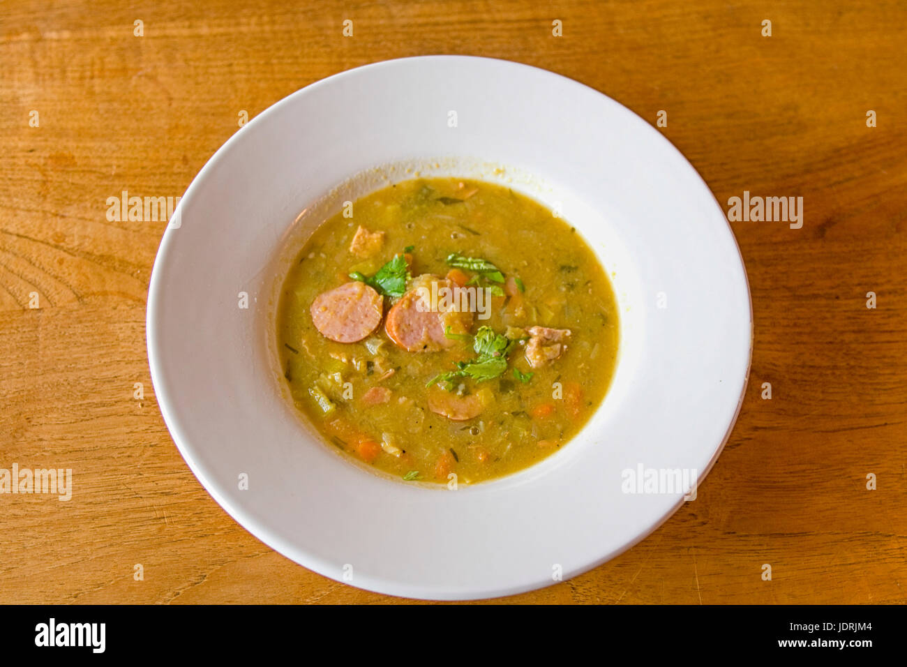 Runde Platte mit grünen Peasoup und Wurst, eine ideale Winter-Suppe Stockfoto