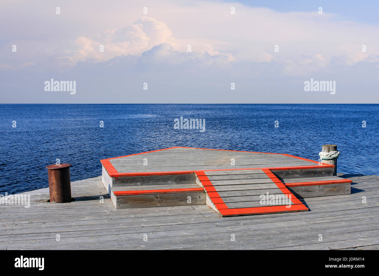 Holzbrücke am Meer. Ruhiges Meer und Wolken im Hintergrund. Horizont. Stockfoto