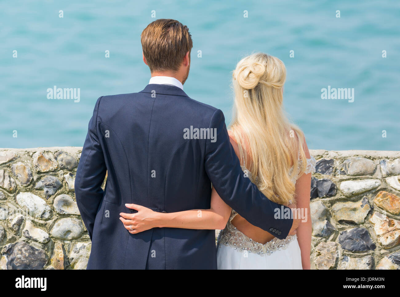 Braut und Bräutigam an einem Strand mit Fotos für ihre Hochzeit. Ehepaar. Zu heiraten. Tag der Ehe. Stockfoto