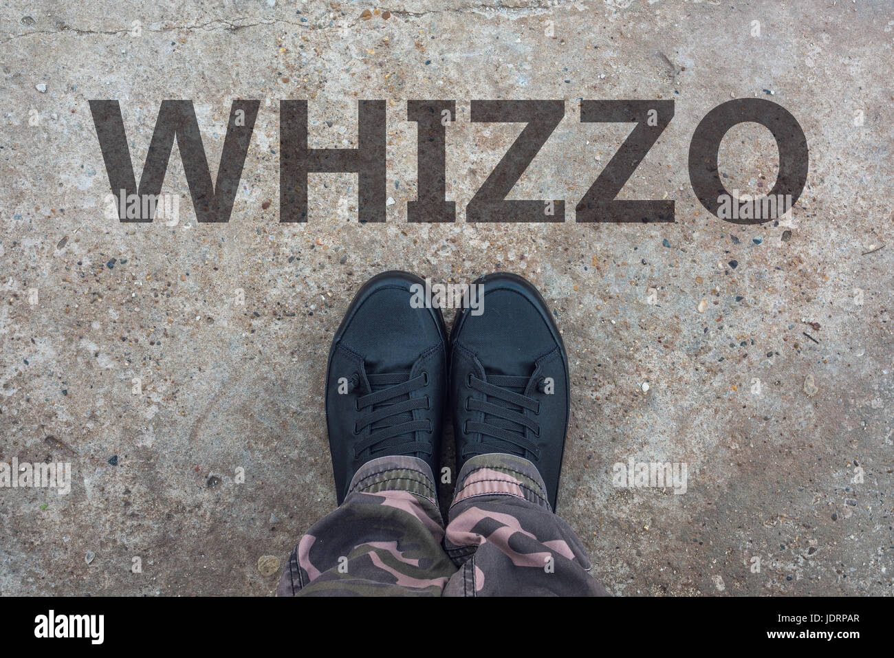 Whizzo, britischer Slang für hervorragende und ausgezeichnete mit neuen modernen Tennisschuhe auf konkrete Bürgersteig Stockfoto