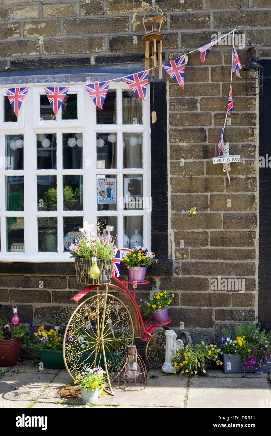 Gartenverzierungen, Union Jack Bunting und Hochrad mit Blumen in Körben Stockfoto