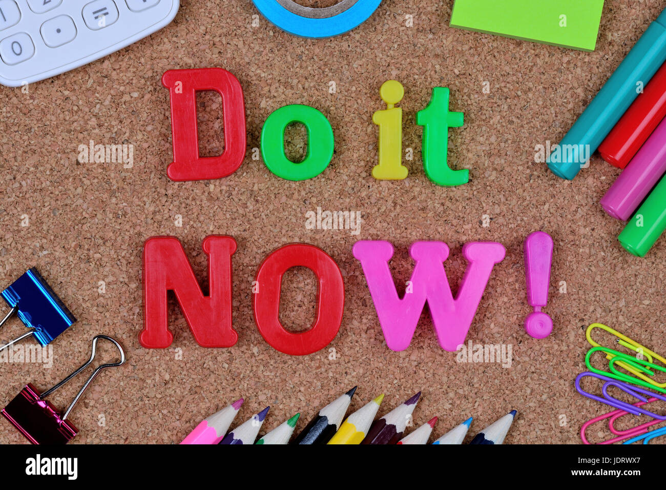 Die Worte tun Sie es jetzt auf Kork-Hintergrund Stockfoto