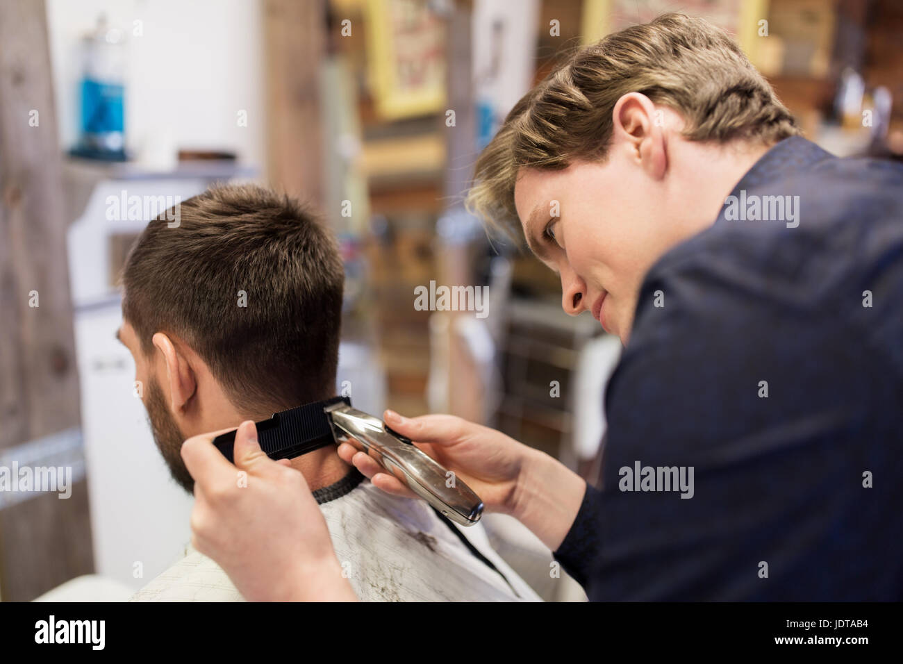 Mann und Barber mit Trimmer Haare schneiden im salon Stockfoto