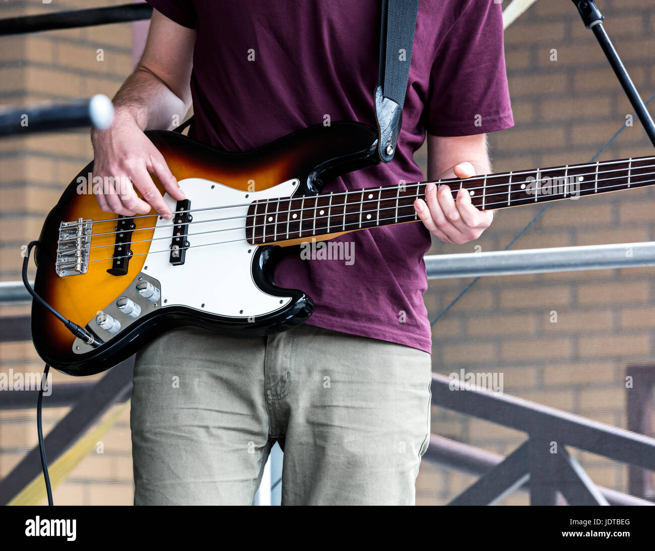 junge Musiker spielt Bassgitarre an der Straße beim Musikfestival Stockfoto