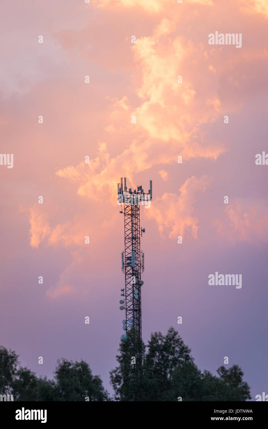 Fernmeldeturm mit Antennen mit Sonnenuntergang Himmel im Hintergrund Stockfoto