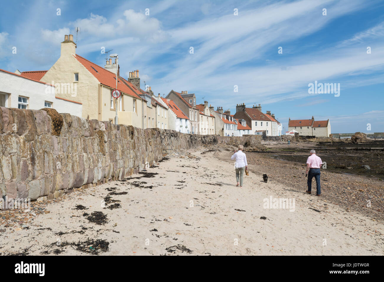 Pittenweem West Shore Strand - paar walking Hund im Sommer, Pittenweem, Fife, Schottland Stockfoto