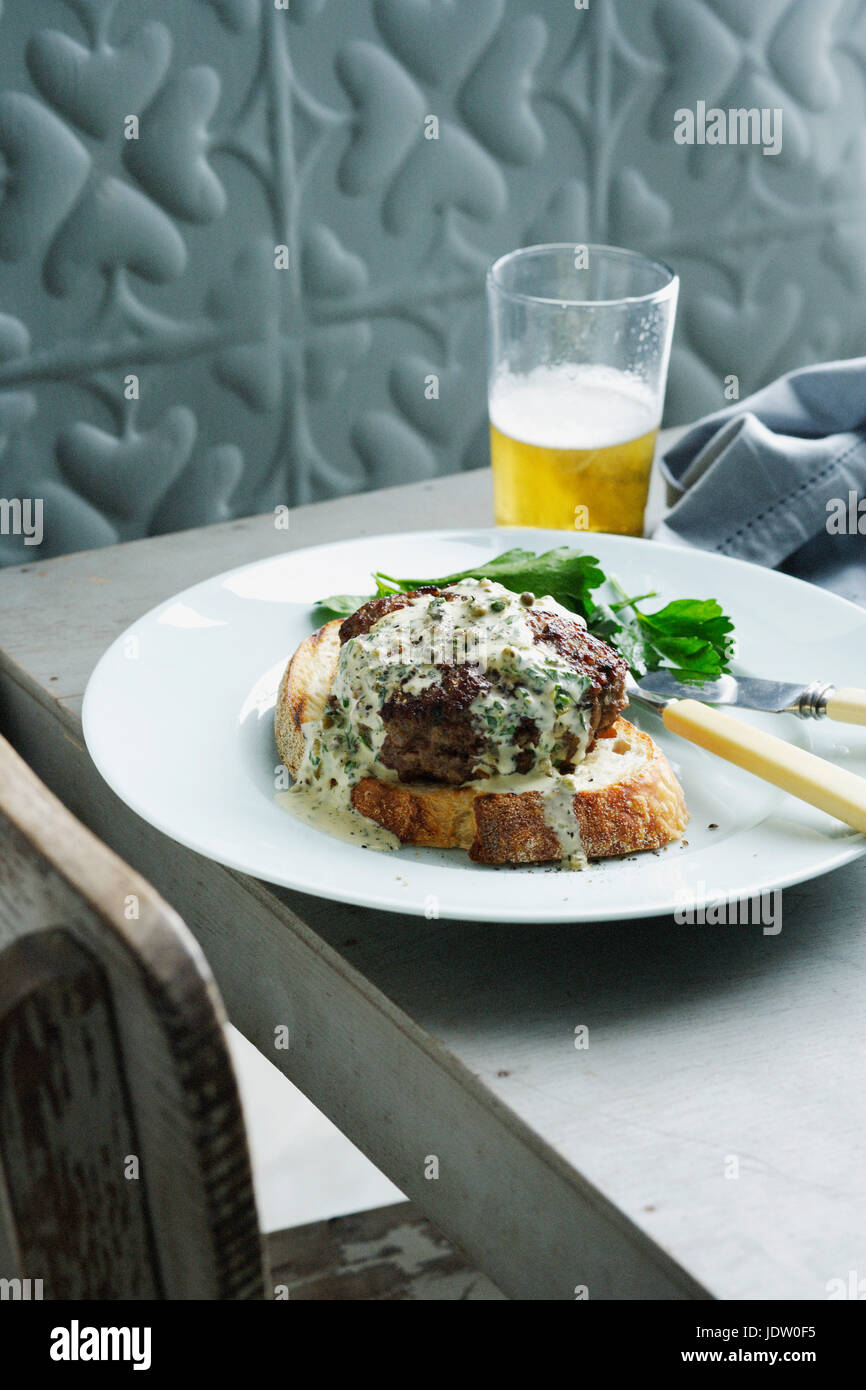 Teller mit Burger mit Kräutersauce Stockfoto