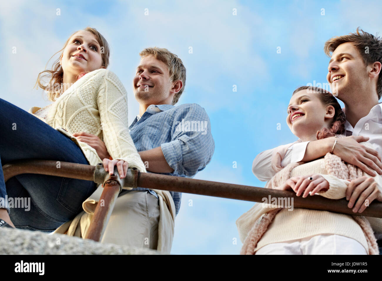 Paare, die am Geländer im Freien stehen Stockfoto
