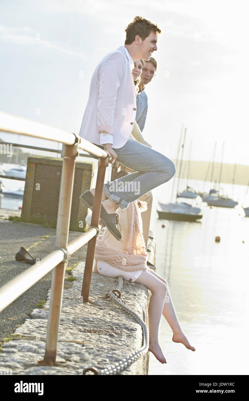 Paare, die sitzt auf dem Geländer der Hafen Stockfoto